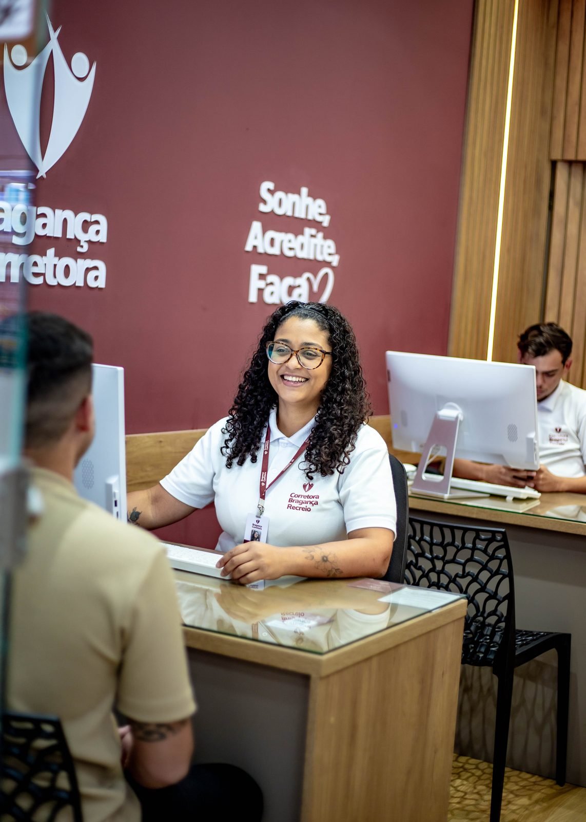 Consultora da Bragança Corretora atendendo um cliente na unidade do Recreio